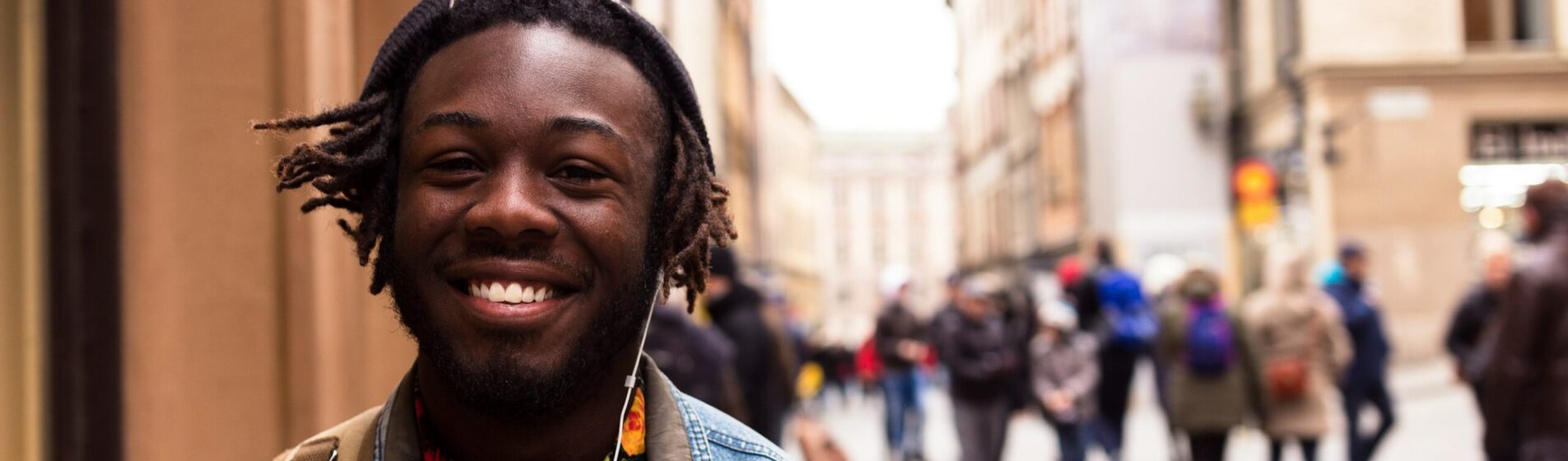 Young adult walking down a city street listening to muisc