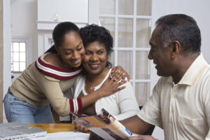 Young Person hugging her mother whilst looking at her father- everyone is happy