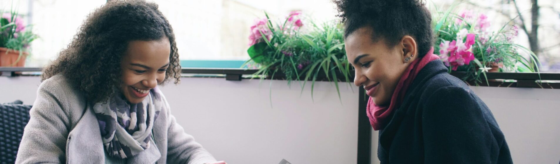 Two teenage girls on their photos facing each other doing the quiz