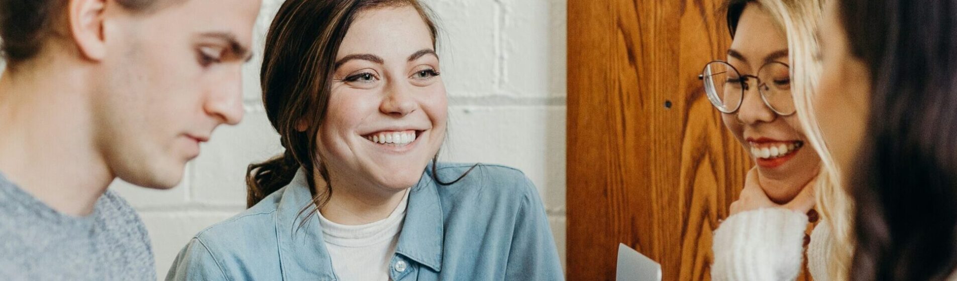 Four young people in a cafe chatting