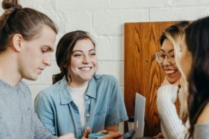 Four young people in a cafe chatting