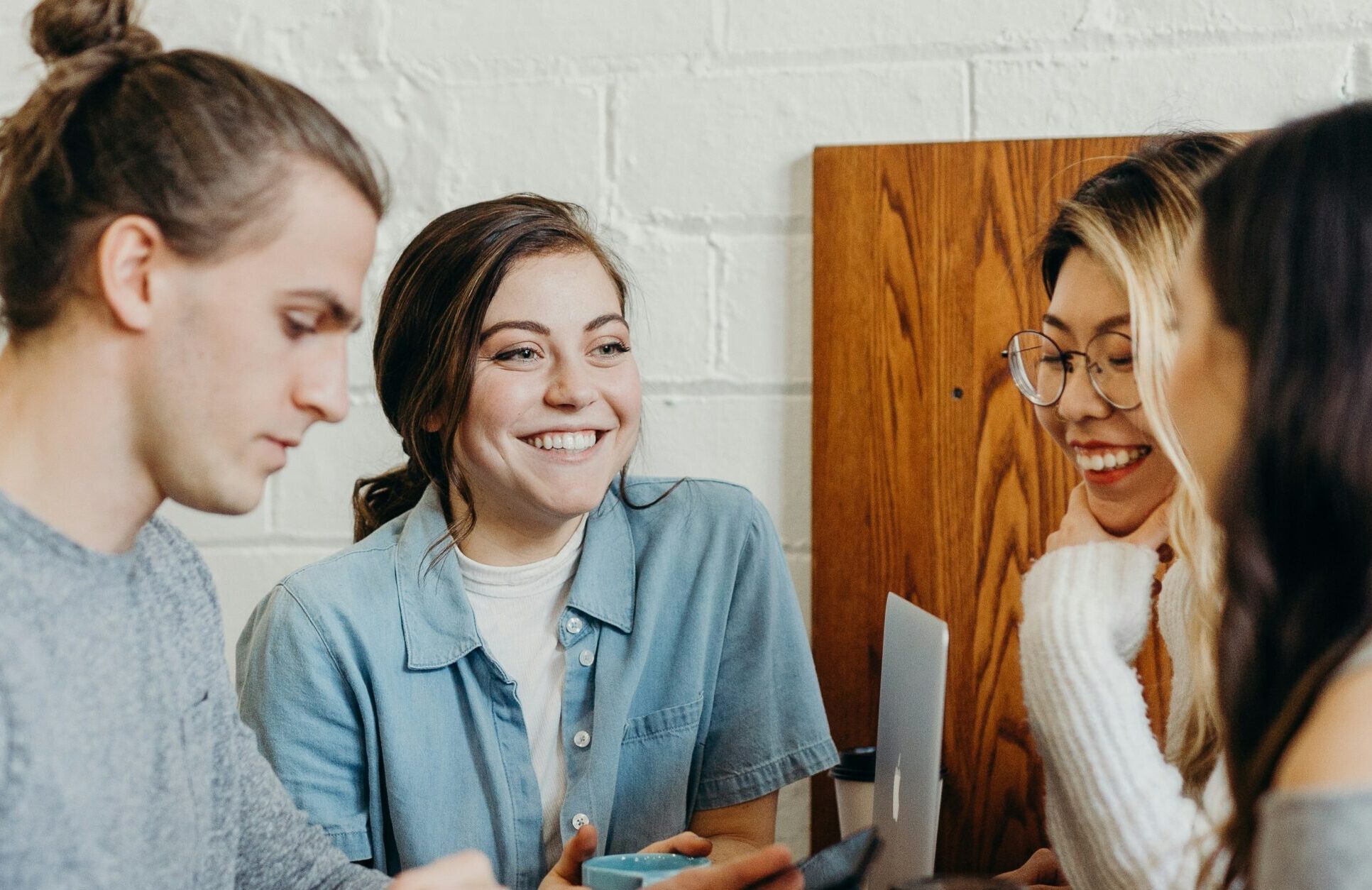 Four young people in a cafe chatting