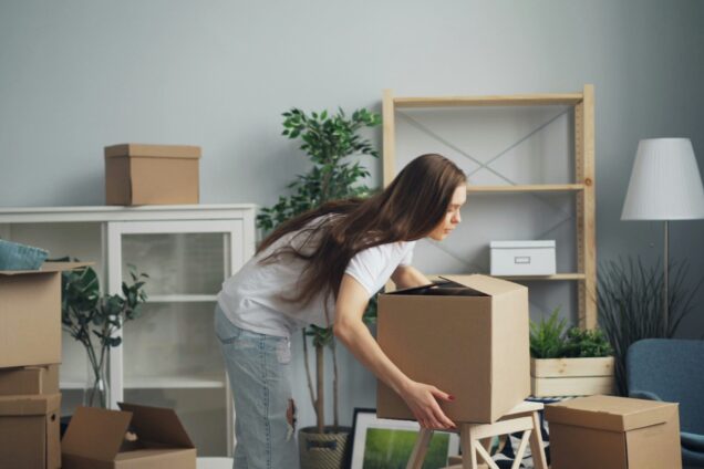 Girl moving into accommodation with boxes