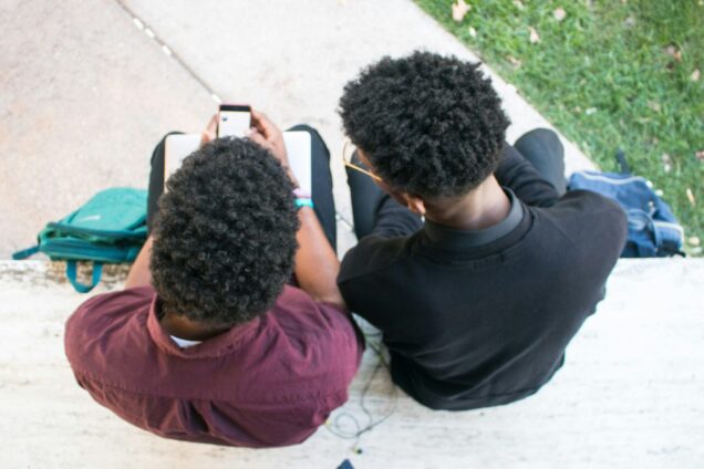 Two males looking at a phone, picture take from above