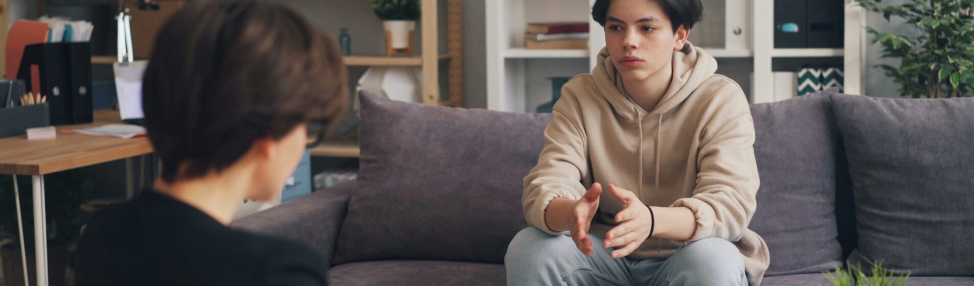 Boy talking to someone making notes