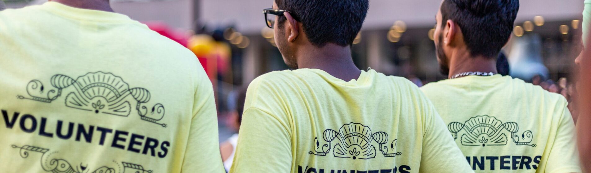 Three boys backs which tops say volunteers