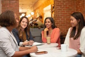 picture of women sitting around a table discussing