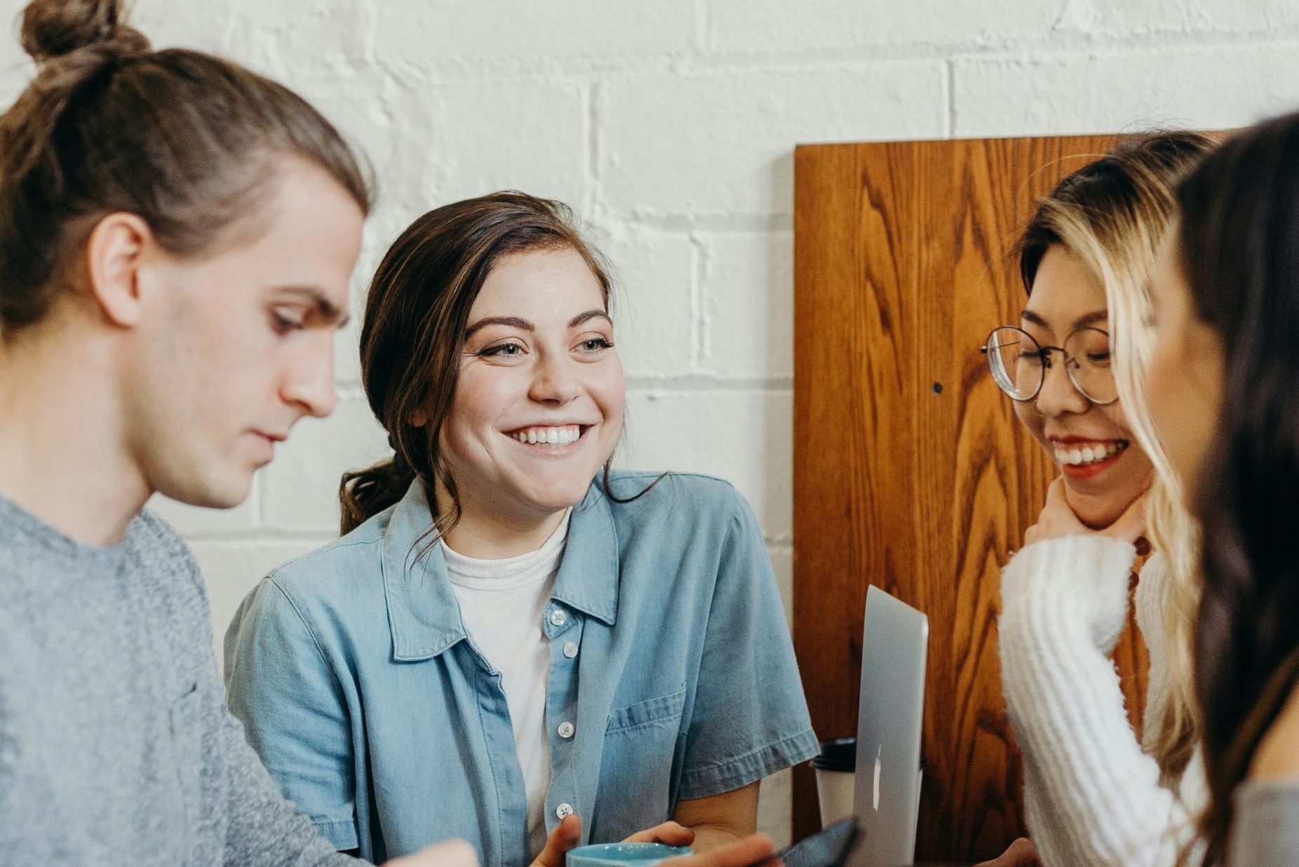 Four young people in a cafe chatting