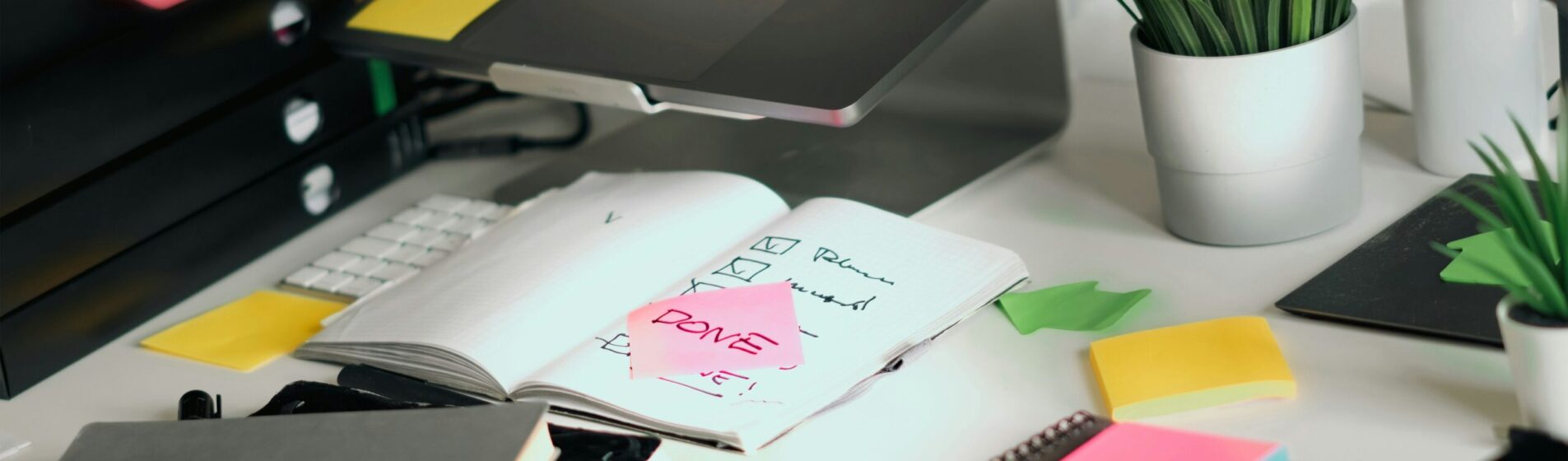 Laptop open with post its and books on a desk