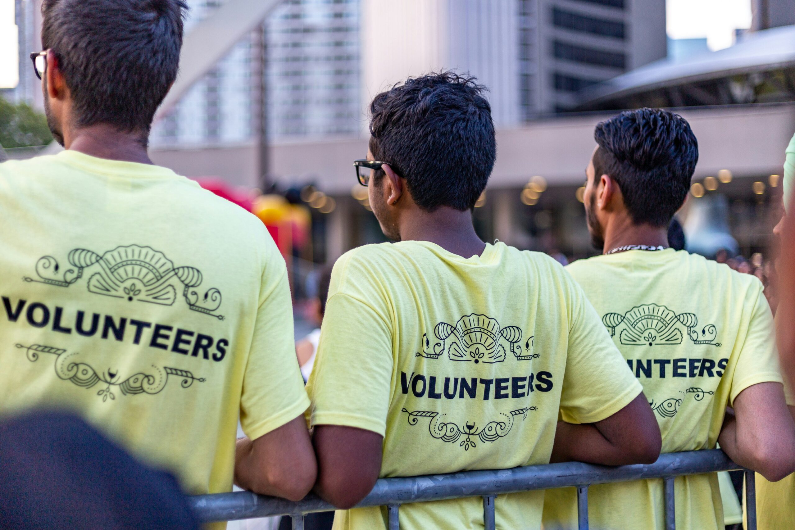Three boys backs which tops say volunteers